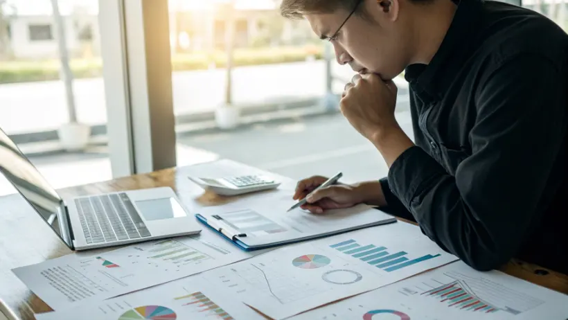 Person deep in thought while reviewing statistical charts and probability graphs