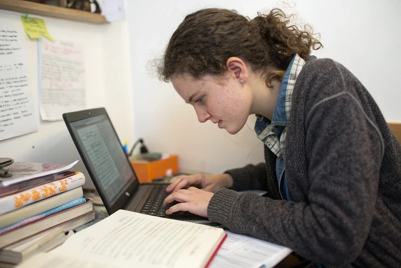 Previously reluctant young writer now enthusiastically typing story on computer with focused, engaged expression
